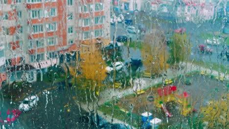 raining heavily in the city. view through the window covered with raindrops. close up.