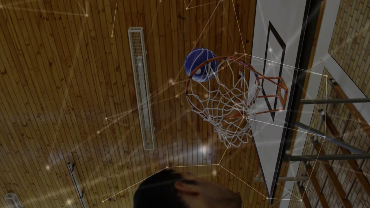 Player receiving pass and driving toward rim to score in gym, sports overlay tracing ball arc