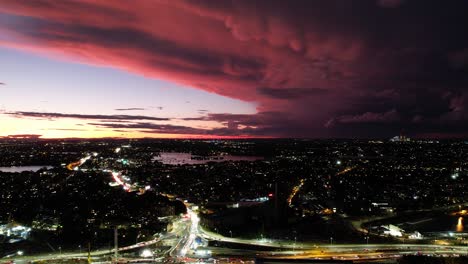 i temporali attraversano il nord-ovest di sydney, in australia in lontananza durante il tramonto mentre il traffico scorre attraverso le strade vicine che collegano alla città