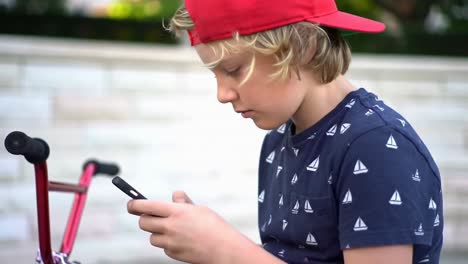 boy texting on smartphone outdoors