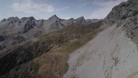4k low-altitude drone shot over the western valleys natural park in the aragonese pyrenees, spain. a cinematic aerial view of the mountain trail leading to ibón de acherito.
