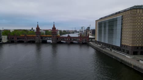 drone flying over the river spree in berlin, towars the famous oberbaumbrücke