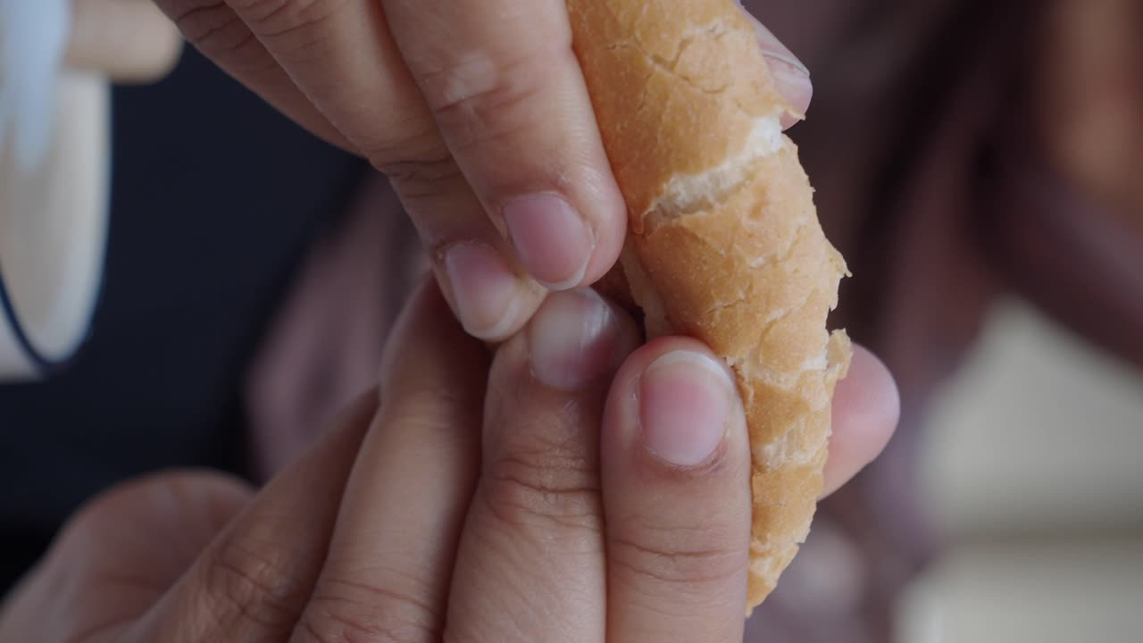 Close up of person breaking bread