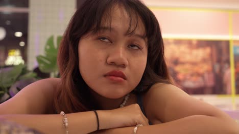 young teenage girl rolling her eyes and looking sad after glancing at her phone.