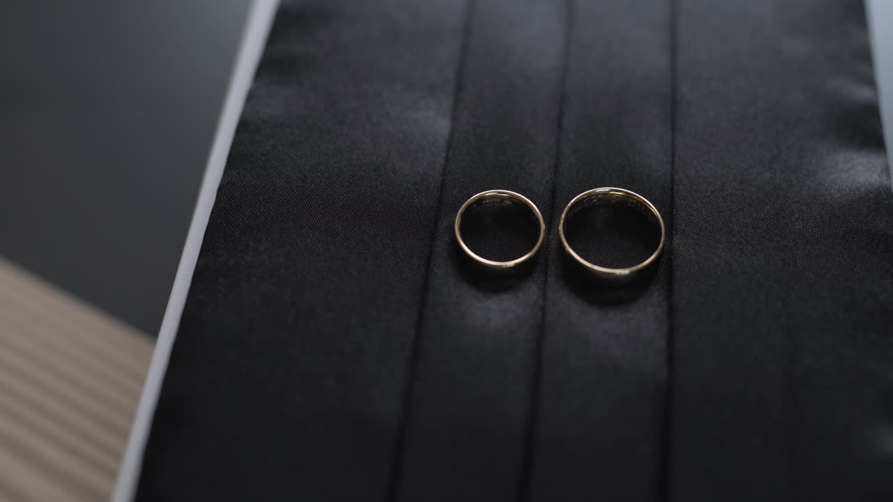 Black Suit Belt and Wedding Rings Close-Up