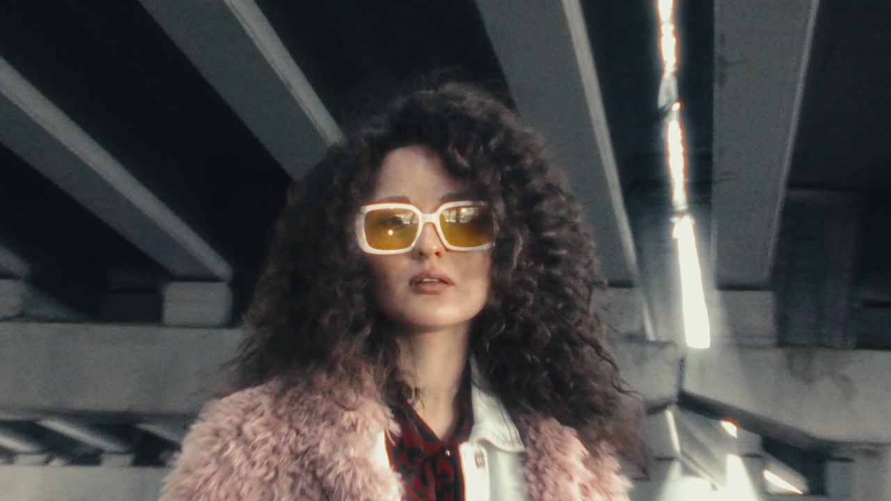 Portrait of Trendy Girl in Sunglasses under Concrete Bridge