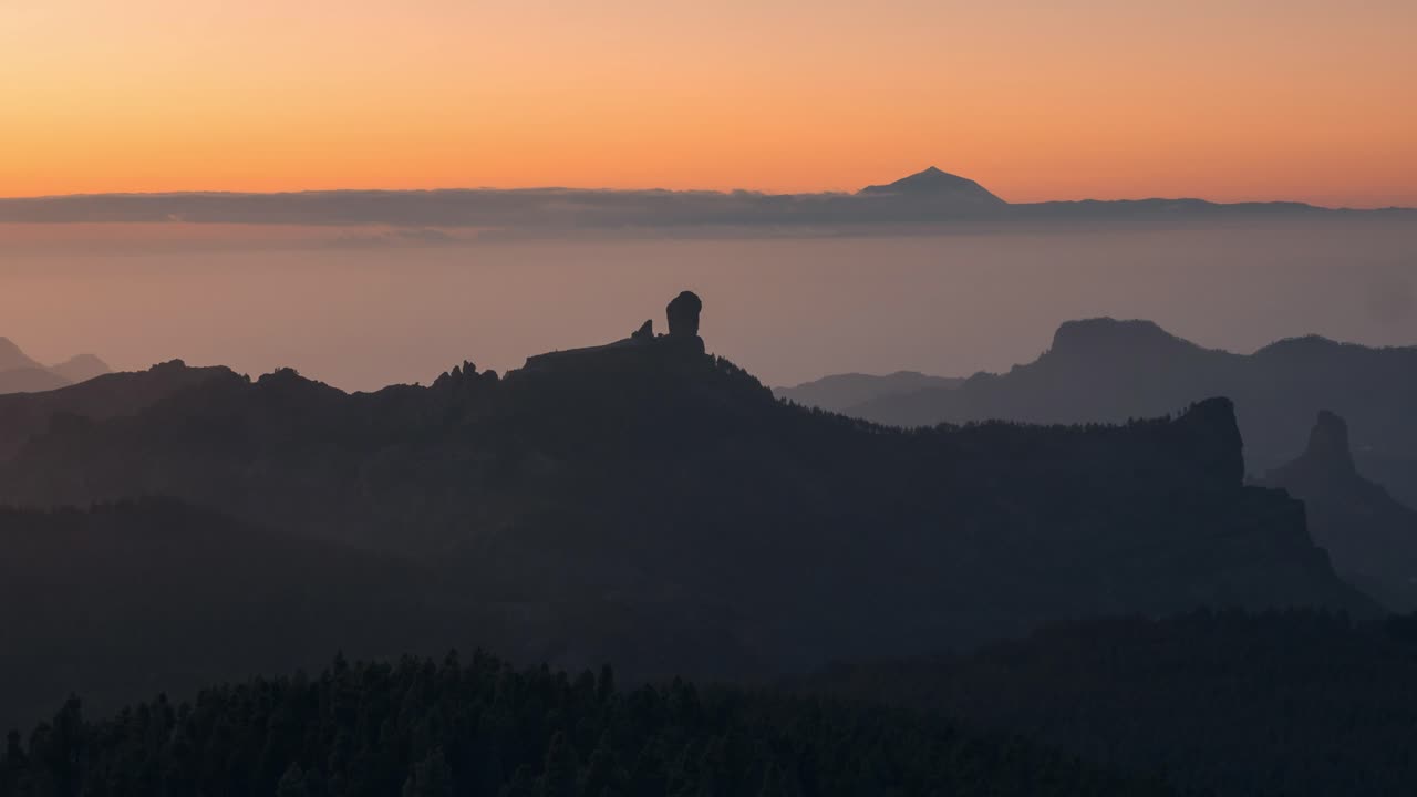 Breathtaking timelapse of Roque Nublo at sunset, with golden light over the mountains and Teide in the distance. A serene and cinematic scene, perfect for nature, travel, and adventure projects.