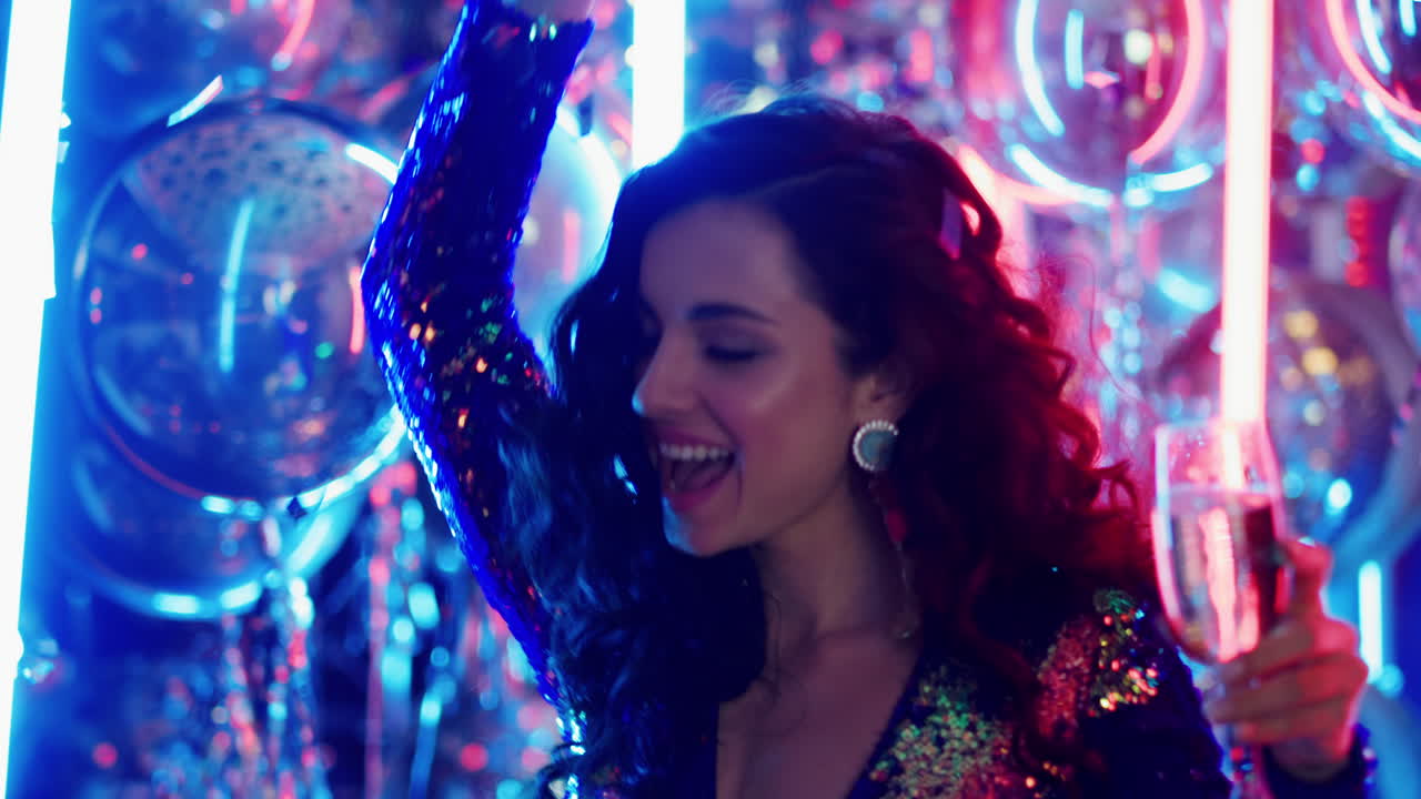 mujer feliz bailando con alcohol en el fondo de neón. chica celebrando en el club
