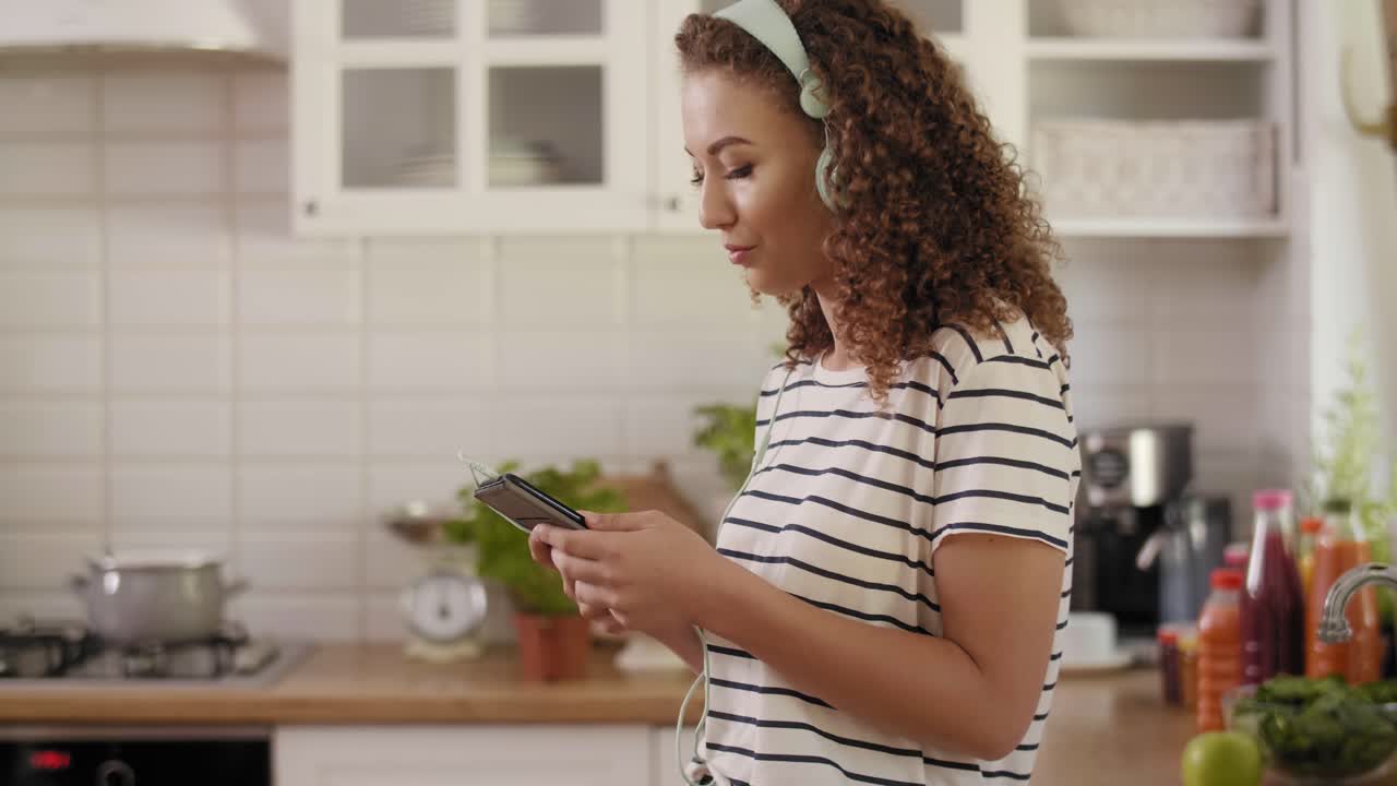mujer escuchando música en la cocina/rzeszow/polonia