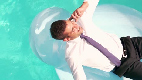 Businessman-having-a-phone-call-on-inflatable-