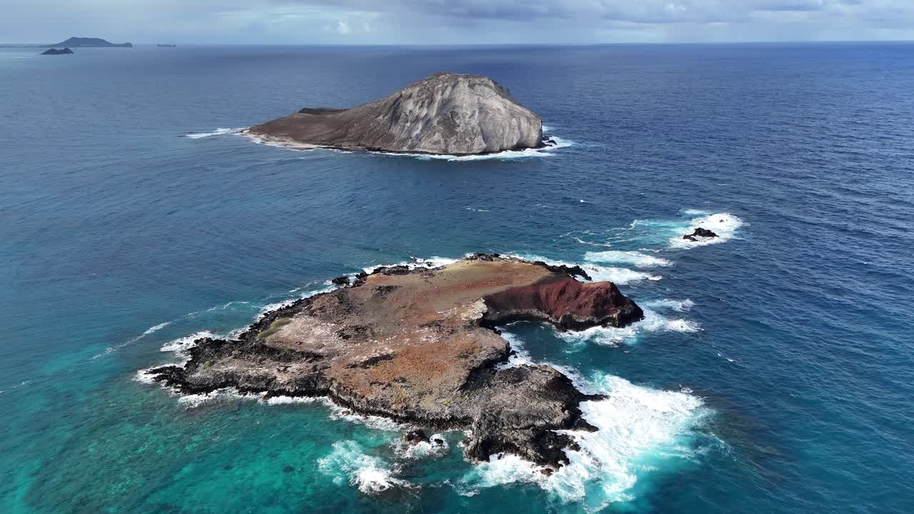 Drone above two small rocky islets off Oahu, Hawaii. Tropical ocean, dramatic coastline, and scenic island scenery captured from above