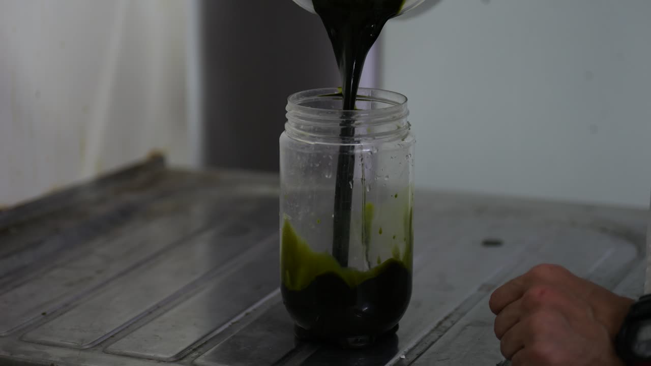 cerca de los trabajadores mano verter agua líquido nutritivo en un frasco