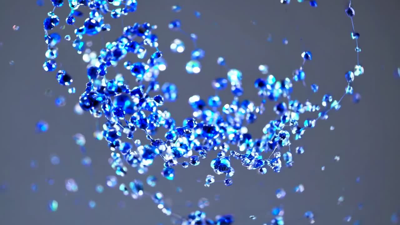 Dynamic close-up video of blue liquid droplets suspended mid-air, captured from a low angle