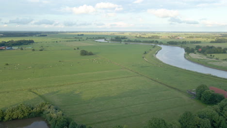 flying towards verdant landscape with river leda near schloss evenburg in leer, germany