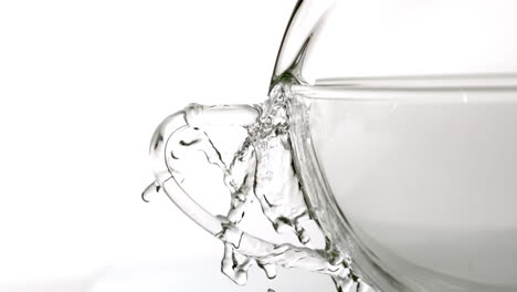 water spilling from glass cup on white background