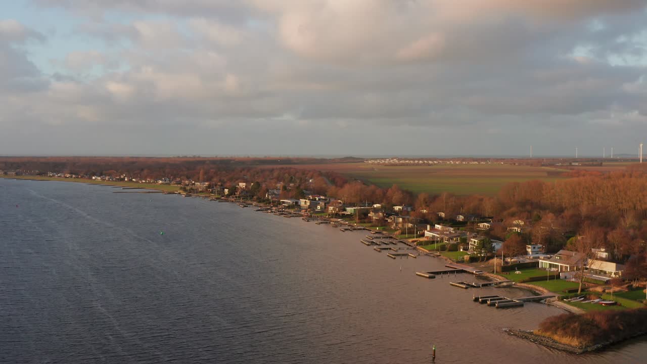 Vacation homes located at a lake during winter. High angle orbit drone shot
