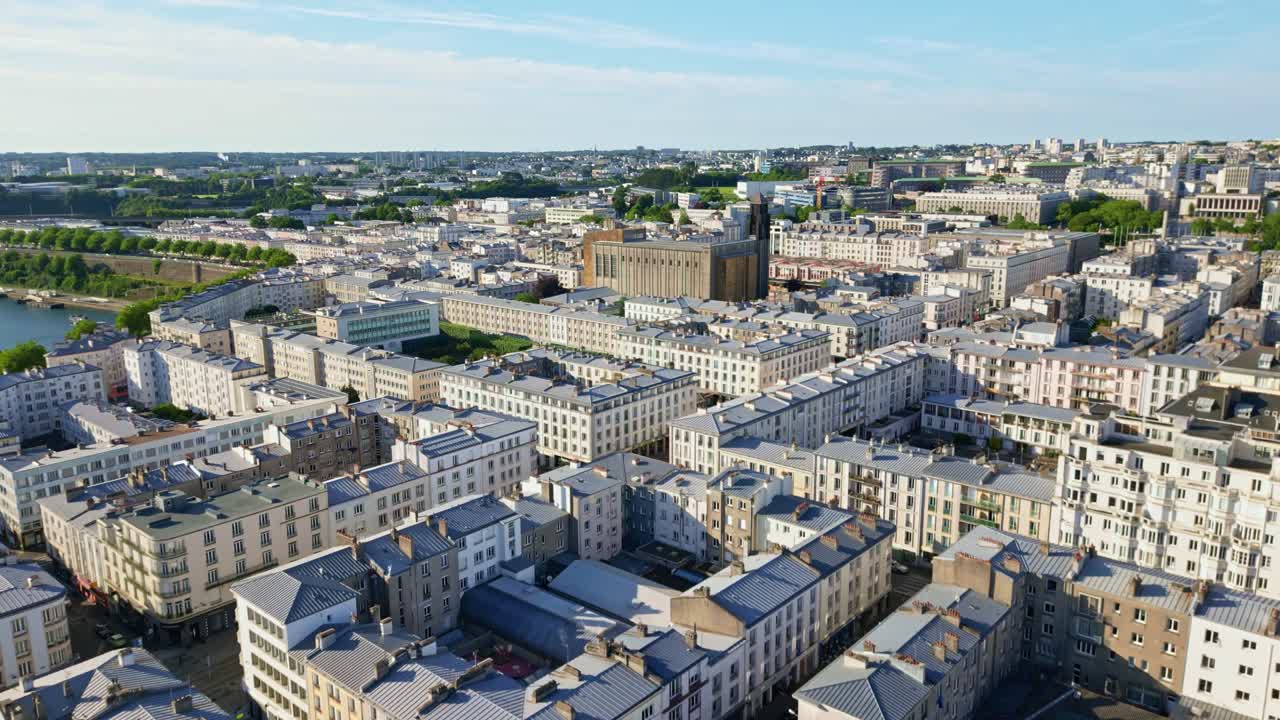Dense city buildings and rooftops in Brest, France, urban landscape and Penfeld river on sunny day. Aerial drone forward