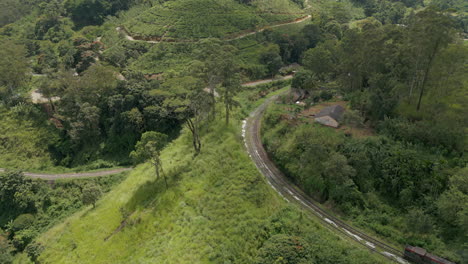 Luftdrohnenaufnahme-Eines-Zuges,-Der-Die-Demodara-Schleife-Hinauffährt-Und-Am-Bahnhof-Demodara-In-Sri-Lanka-Hält