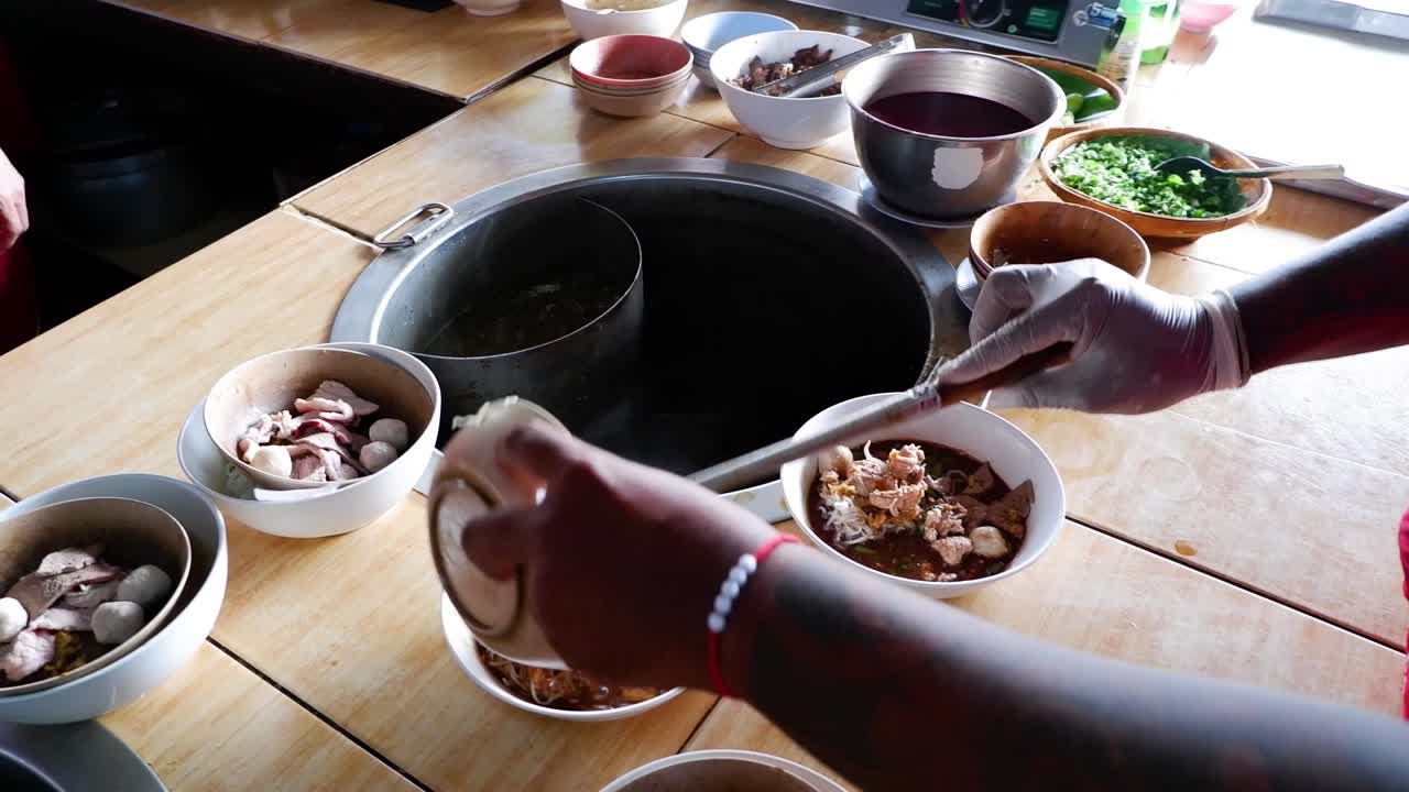 요리사는 다양한 재료로 누들 그을 준비하고 있습니다.