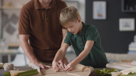 father and son making a gift together