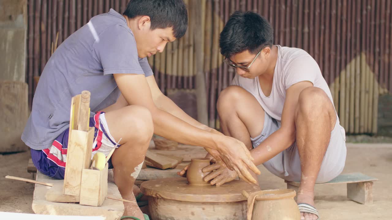 ชายสองคนกำลังปั้นหม้อบนแป้นหมุนด้วยกัน, วิดีโอ 4K