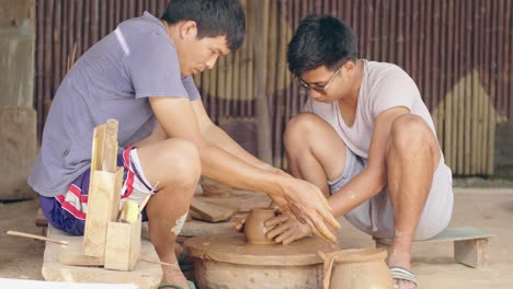 two men working in the potter's wheel together, video in 4k