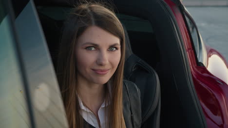 portrait charming woman sitting inside charging electric car young modern girl looks from the phone