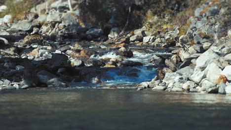 un pequeño arroyo en cascada sobre la costa rocosa cae en el fiordo de naeroy