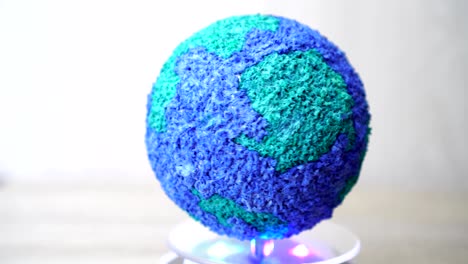 creating rotating of models paper craft earth globe, spinning world global ecology on gray background. loop created in 4k