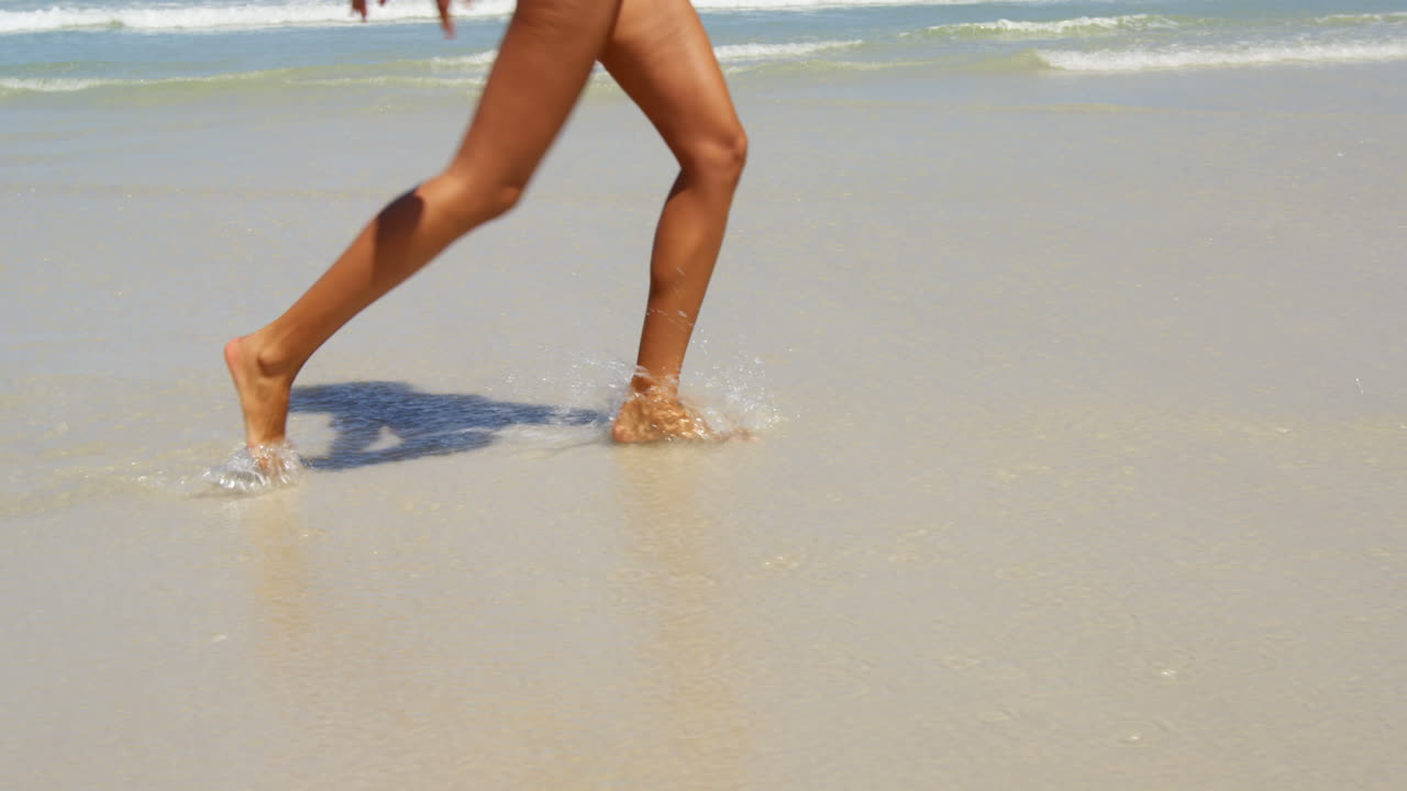 Donna che si diverte in spiaggia in una giornata di sole 4k