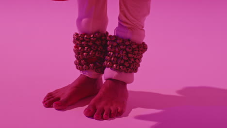 cerca de los pies y las campanas de la bailarina de kathak femenina que realiza el baile vestida con el vestido tradicional indio contra un fondo púrpura 5