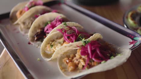 a handheld shot of a sampler platter of shrimp and fish tacos in a traditional sinaloan mexican restaurant