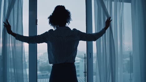 business-woman-opening-curtains-in-hotel-room-looking-out-window-at-fresh-new-day-successful-independent-female-planning-ahead-on-cloudy-morning