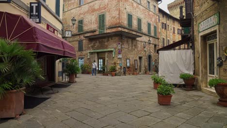 bars and restaurants along cobbled street in lucignano, arezzo, italy