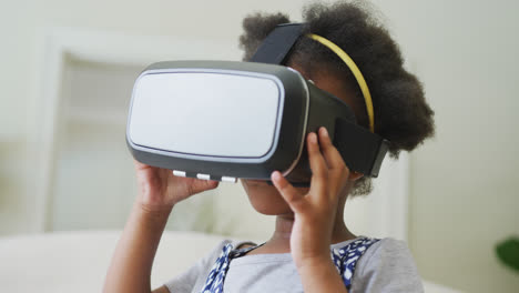 Niña-Afroamericana-Sonriente-Jugando-Con-Auriculares-Vr-En-La-Sala-De-Estar