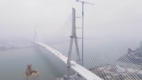 aerial view of fog covered gordie howe bridge connecting detroit, usa and windsor, canada