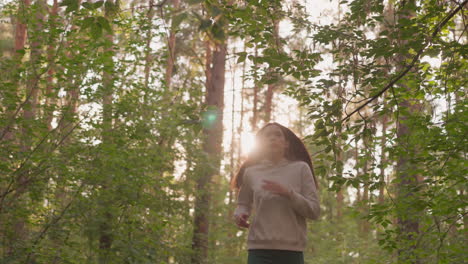 female runner jogging across forest at morning dawn. young woman enjoys cardio activity surrounded by dense trees. active morning routine to shape body