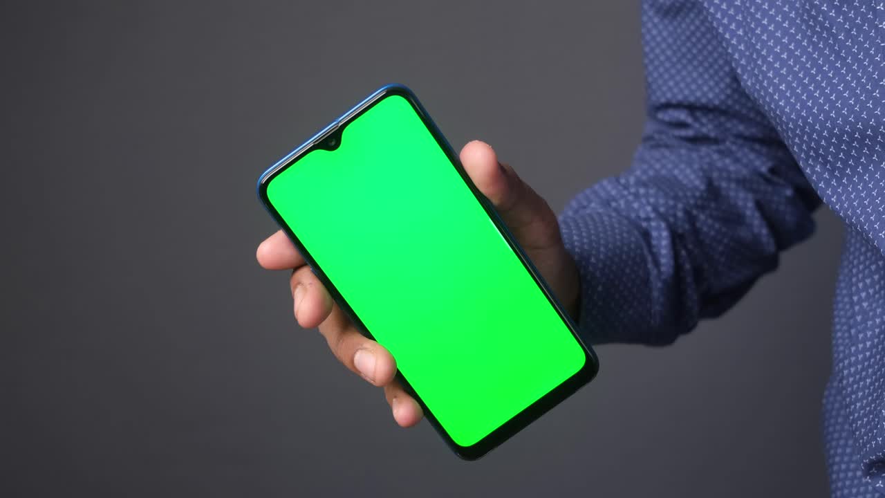 persona que sostiene un teléfono inteligente con una pantalla verde