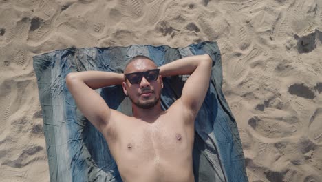 hombre tomando el sol en la playa