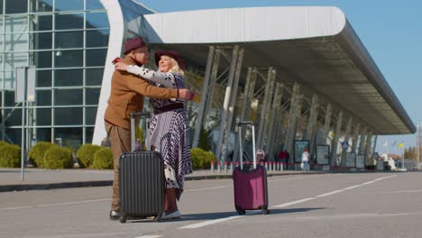 elderly old husband wife retirees tourists reunion meeting in airport terminal after long separation