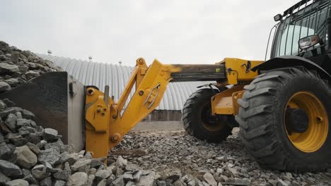 tractor moves rubble to truck. excavator-loader rakes rubble from pile at construction site and loads dump truck. clearing site