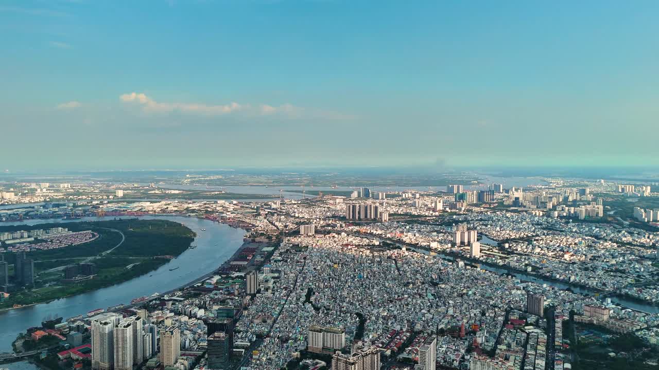 Aerial: sunset, Saigon River and cityscape in Ho Chi Minh City, Vietnam, pan drone shot