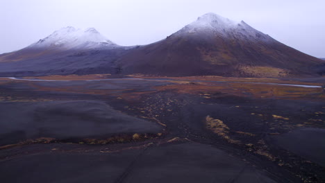 Raining-on-snow-capped-volcanic-mountains-and-black-lava-field-in-Iceland