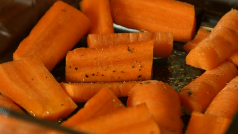 chopped carrots being seasoned with pepper ready to be cooked