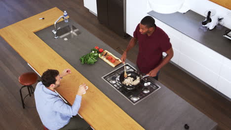 overhead view of men preparing meal and talking in kitchen