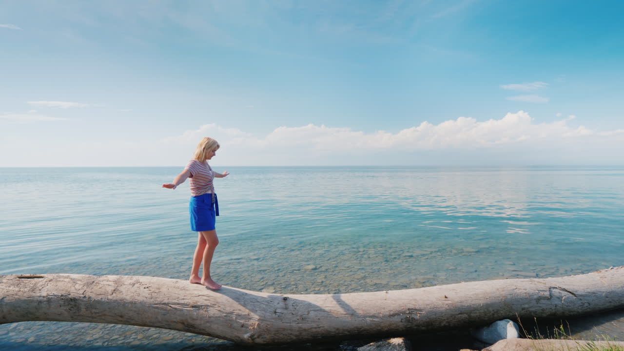 균형잡힌 통나무 위를 걷는 평온한 여성