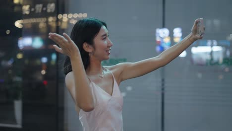 young woman taking selfie in night city