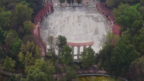 people walking on an skating rink with polluted mexico city behind them