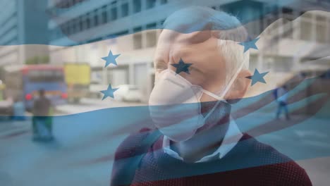 Animation-of-flag-of-honduras-waving-over-caucasian-man-wearing-face-mask-in-city-street