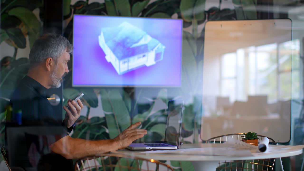 Executive talking on mobile phone while using laptop in meeting room 4k